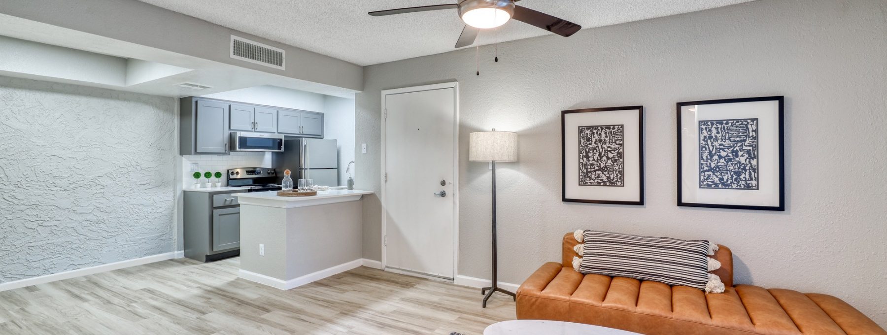 a living room with a ceiling fan and a couch at The Senara