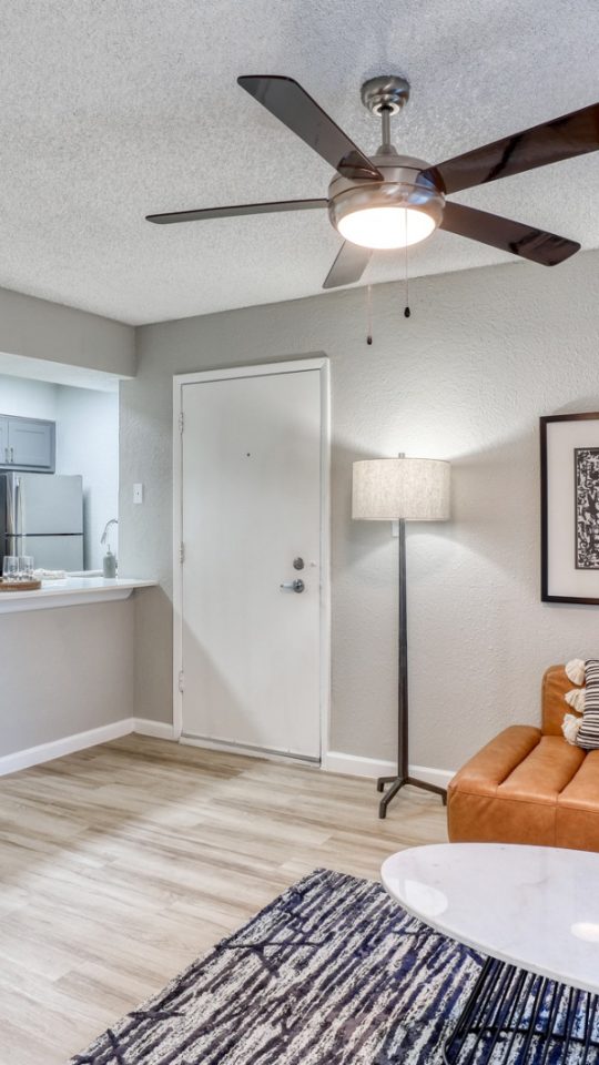 a living room with a ceiling fan and a couch at The Senara